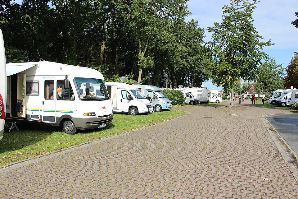 Mehrere weiße Wohnmobile auf dem Stellplatz der Gemeinde Ostrhauderfehn.