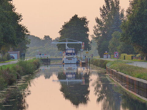 Kanalblick mit einem weißen Schiff und einer Klappbrücke in der Ferne