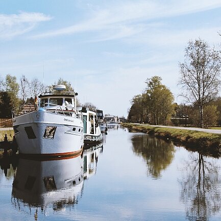 Bootsanleger mit einem Boot auf der linken Kanalseite, zum größten Teil in weiß gestrichen 