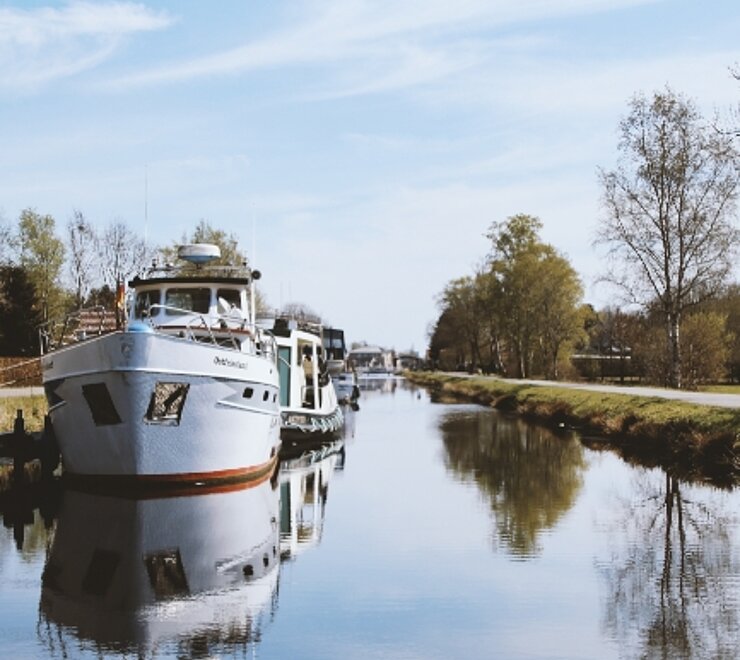 Bootsanleger mit einem Boot auf der linken Kanalseite, zum größten Teil in weiß gestrichen 